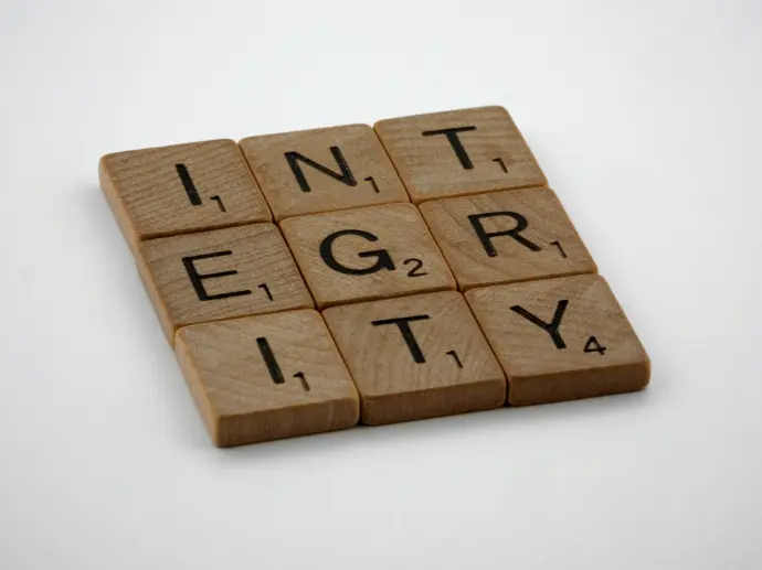 a scrabbled wooden block with the words integr city on it